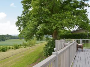 a porch with a white fence and a tree at Wattles-E4527 in Uplowman