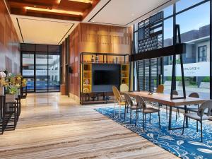 a dining room with a television and a table and chairs at Mercure Berau in Tanjungredep