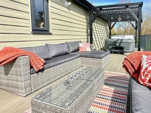 a patio with a couch and a grill at Talltrees - Uk42842 in Uplowman