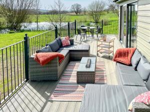 a patio with a couch and a table on a deck at Talltrees - Uk42842 in Uplowman