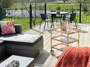 a patio with a couch and a table and chairs at Talltrees - Uk42842 in Uplowman