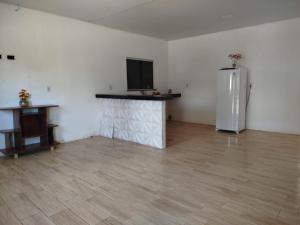 an empty room with a refrigerator and a wooden floor at Casa veraneio in Soure +3 photos