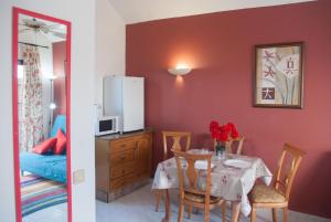 a dining room with a table and a refrigerator at Bungalow Montecastillo 2 in Caleta De Fuste