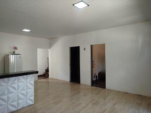 an empty room with white walls and wooden floors at Casa veraneio in Soure