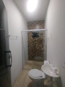 a bathroom with a shower and a toilet and a sink at Casa veraneio in Soure