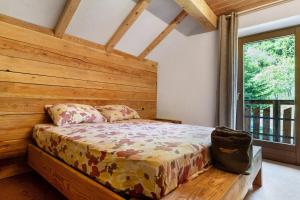 a bedroom with a bed in a room with a window at Baita Dal Bigolaro in Levico Terme