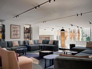 a living room with couches and tables at TRIBE Paris Pantin in Pantin