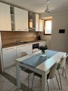 a kitchen with a table and chairs and a kitchen with white cabinets at Appartamento Cavour in Ventimiglia