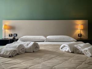 two beds in a room with towels on them at Hotel Futuro in Aversa