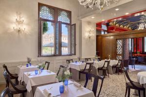 a restaurant with white tables and chairs and a window at Hotel Palazzo Stern in Venice