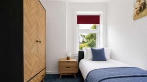 a bedroom with a bed and a window at Parkview Apartment in Rothesay
