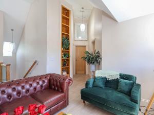 a living room with a leather couch and a chair at Kendalls Nook in Shaftesbury