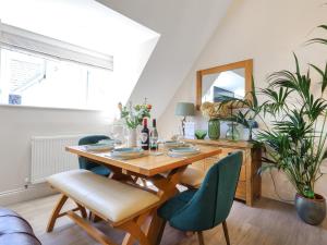 a dining room with a wooden table and chairs at Kendalls Nook in Shaftesbury