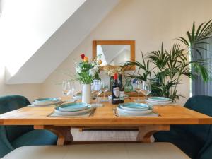 a dining room table with plates and wine glasses at Kendalls Nook in Shaftesbury