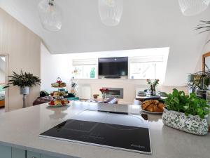 a kitchen with a table with a tablet on a counter at Kendalls Nook in Shaftesbury +27 photos