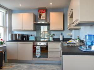 a kitchen with white cabinets and a stove at Seagulls Lookout in Weymouth