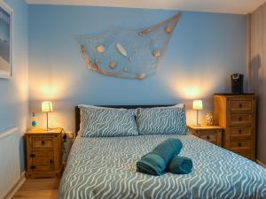 a bedroom with a bed with a blue comforter at Seagulls Lookout in Weymouth