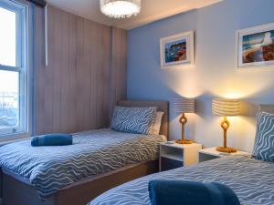 a small room with two beds and a couch at Seagulls Lookout in Weymouth