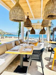 a restaurant with a table and chairs on the beach at Lindian Jewel Hotel and Villas in Lindos