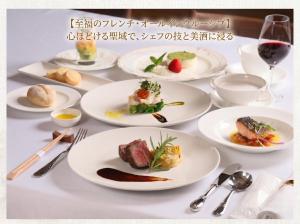 a white table with plates of food on it at 友愛ファームゲストハウス in Hatoyama