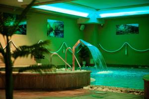 a swimming pool with a hot tub and a water slide at Hotel St. Bruno in Giżycko