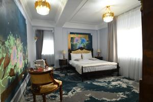 a bedroom with a bed and a painting on the wall at Pensiunea Paradis in Râmnicu Vâlcea