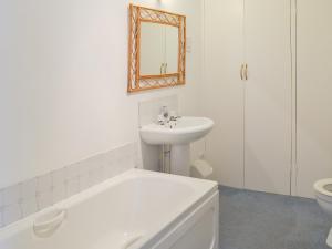 a bathroom with a sink and a toilet and a mirror at Topsail in Newton Ferrers