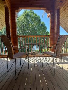 two chairs and a table on a porch at Au bord du lac III in Montigny-en-Morvan