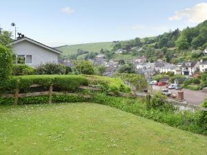 a field of grass with a fence and a town at Topsail in Newton Ferrers +6 photos