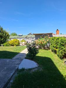 a house with a yard with grass and flowers at Frix Balaton in Balatonalmádi