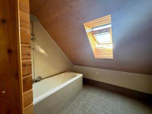 a bathroom with a bath tub and a window at Au bord du lac III in Montigny-en-Morvan +10 photos