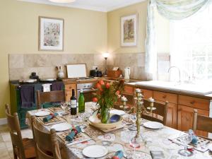 a kitchen with a table with a table cloth on it at Lochside Garden House - S4484 in Town Yetholm
