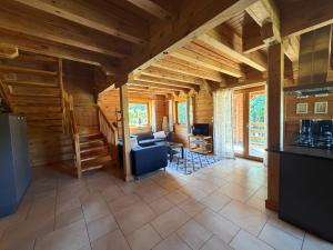 a kitchen and living room in a log cabin at Au bord du lac III in Montigny-en-Morvan