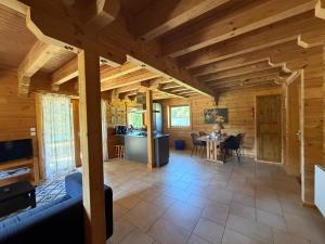 a living room and kitchen in a log cabin at Au bord du lac III in Montigny-en-Morvan