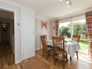a dining room with a table and chairs and a window at Sheeoch in Comrie