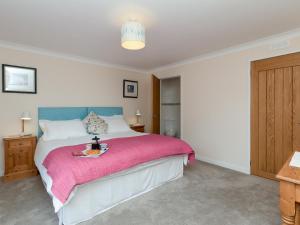 a bedroom with a bed with a pink blanket at Sheeoch in Comrie +15 photos