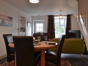 a dining room with a table with wine glasses at Coniston Cottage in Coniston