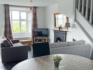 a living room with a couch and a table at Coniston Cottage in Coniston