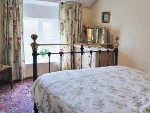 a bedroom with a bed and a window with curtains at Ryecroft in Bradwell