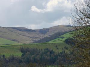 a green field with trees and mountains in the background at Ryecroft in Bradwell +2 photos