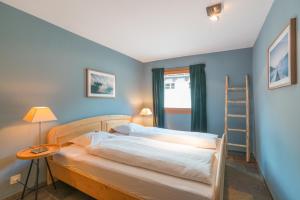 a bedroom with two beds and a ladder at Chesa Survial 4 in Sils Maria
