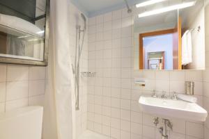 a white bathroom with a sink and a shower at Chesa Survial 4 in Sils Maria +11 photos