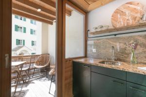 a kitchen with a sink and a view of a patio at Chesa Survial 4 in Sils Maria
