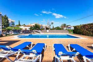 a villa with a swimming pool and lounge chairs at Apartamento Veleta Puerto Pollensa in Pollença