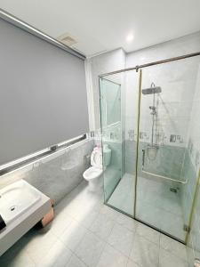 a bathroom with a glass shower and a toilet at Tropical Bay Villas and Homestay in Phú Quốc