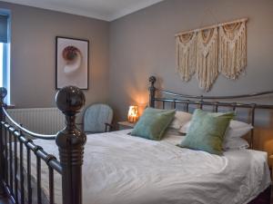 a bedroom with a bed with green pillows at Marina Views in Amble
