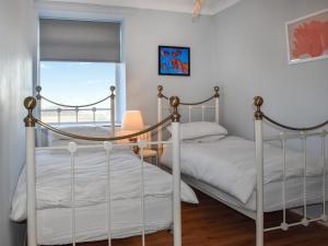 two beds in a bedroom with a window at Marina Views in Amble