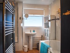a small bathroom with a sink and a window at Marina Views in Amble