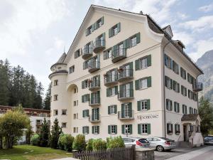 a large white building with cars parked in front of it at Residenza Alpenrose 22 in Sils Maria
