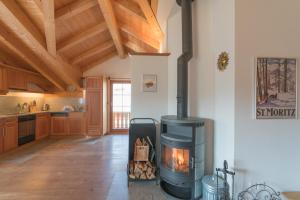 a kitchen with a wood stove in a room at Trais Fluors C3 in Maloja